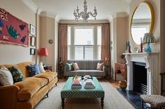 a living room filled with furniture and a fire place in front of a mirror on the wall