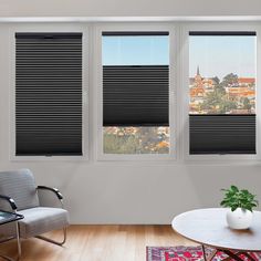 a living room with three windows and a chair in front of the window that has blinds on it