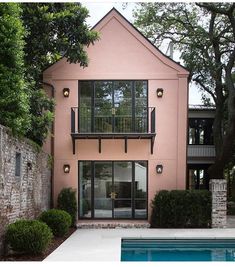 a pink house with two balconies on the second floor