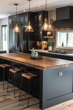 a kitchen with black cabinets and wooden counter tops