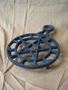 a blue metal object sitting on top of a piece of paper next to a pentagram