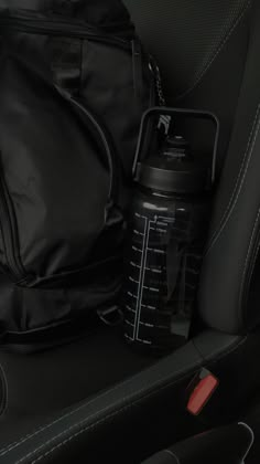 the back seat of a car with a backpack and water bottle