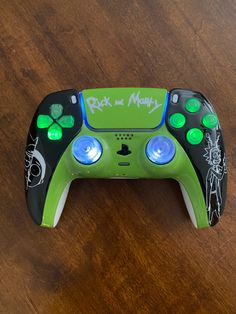 a green and black game controller sitting on top of a wooden table