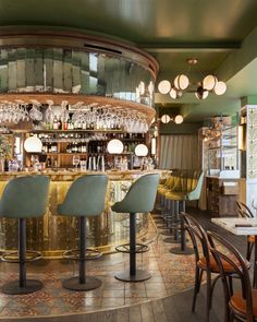 a bar with several chairs around it and lights hanging from the ceiling over the bar