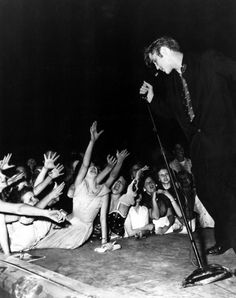 a man standing on top of a stage surrounded by people