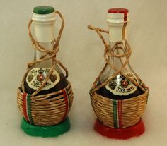 two small bottles with labels on them sitting next to each other in wicker baskets