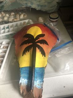 a painted surfboard with a palm tree on it sitting on top of a counter