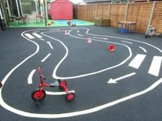 a small child's tricycle is in the middle of an outdoor play area