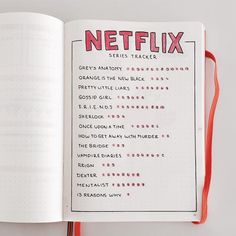 an open notebook with the words netflix written in red on it and a pen next to it