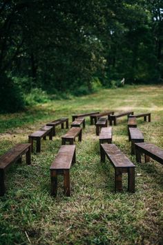 several wooden benches sitting in the grass