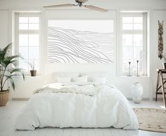 a bedroom with white walls and large windows