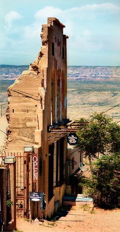 an old building in the middle of nowhere with no people around it and mountains in the background