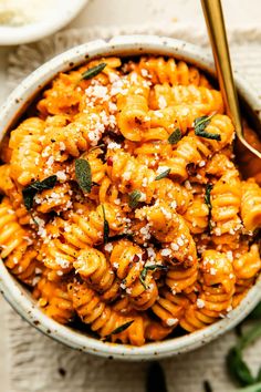 a bowl filled with pasta and topped with parmesan cheese