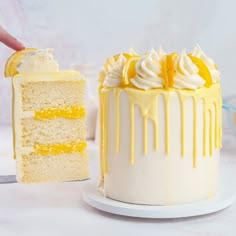 someone is holding a slice of cake with lemon icing on it and the rest of the cake has been eaten