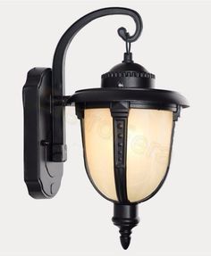 an outdoor wall light with a white glass shade on the front and side of it