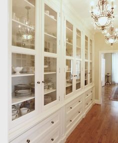 a white china cabinet with glass doors and lights on it's sides in a room