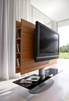 an entertainment center with a television and dvd's on the shelf, in front of a window