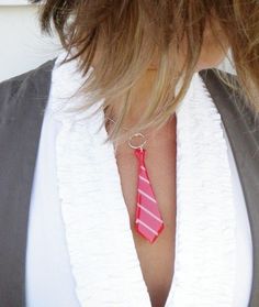 a woman wearing a red and white neck tie with a ring on it's end