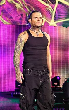 a man with tattoos standing on stage