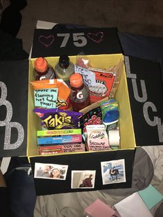 a box filled with lots of food on top of a bed next to other items