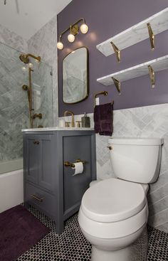 a white toilet sitting in a bathroom next to a sink and bathtub under a mirror