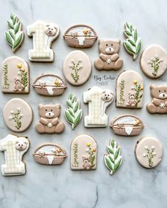 cookies decorated with teddy bears and flowers on a marble countertop for first birthdays