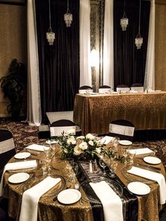 the table is set with white and gold linens for an elegant dinner party setting