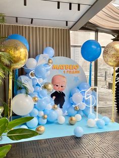 balloons and streamers are set up in front of a backdrop for a baby's first birthday