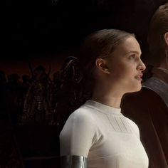 a man and woman standing next to each other in front of a star wars poster