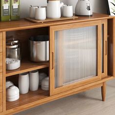 a wooden cabinet with teapots and cups on it