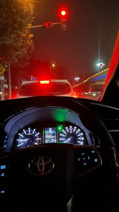 the dashboard of a car at night with red, green and blue lights in the background