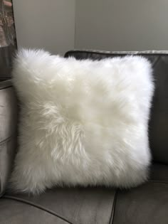 a white fluffy pillow sitting on top of a couch