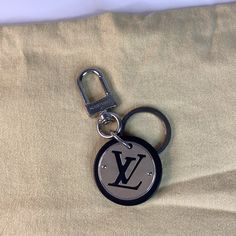 a louis vuitton keychain is laying on a bed