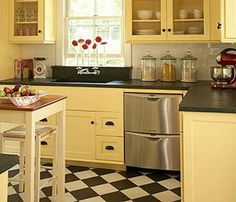 a kitchen with yellow cabinets and checkered flooring on the tile counter tops, along with a stainless steel dishwasher