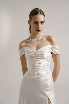 a woman in a white dress posing for the camera