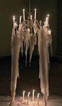 a chandelier with icicles hanging from it's sides and lit candles in the middle