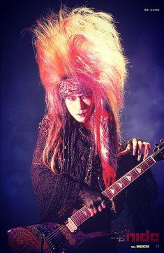 a woman with long hair playing an electric guitar