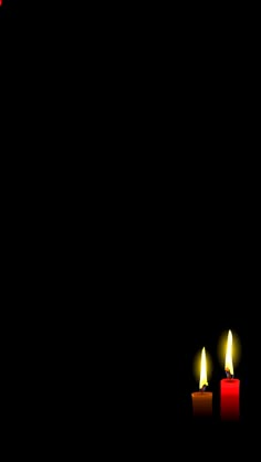 two lit candles on a black background