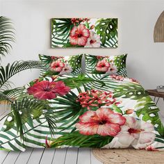 a bed with pink flowers and palm leaves on the cover is next to a potted plant