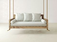 a wooden swing bed with white pillows on it