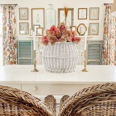 two wicker chairs sitting on top of a white table in front of a fireplace