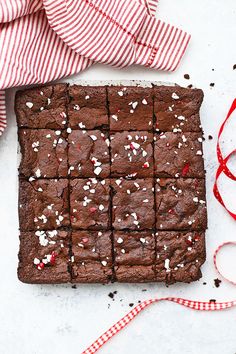 a chocolate brownie with sprinkles on it and a red striped napkin