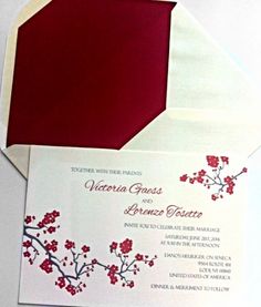 an open envelope with a red and white floral design on it, sitting next to a card