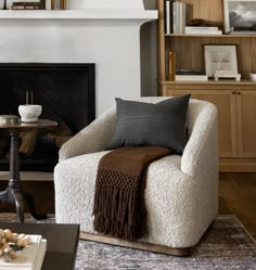 a living room filled with furniture and a fire place in front of a white fireplace