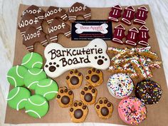 an assortment of decorated cookies and dog treats on a brown paper bag that says barkcurfie board