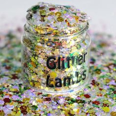 a jar filled with lots of glitter sitting on top of a table covered in confetti