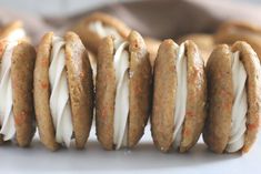 four cookies with white frosting and orange sprinkles on them are lined up