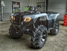 a large four - wheeler parked in front of a building with two tires on it