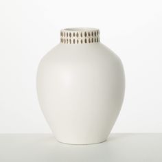 a white vase sitting on top of a table