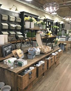 the inside of a flower shop with lots of items on display and flowers in baskets